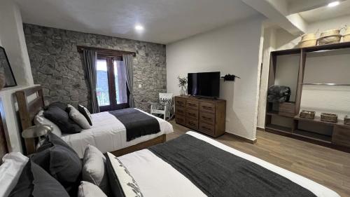a hotel room with two beds and a television at Anae en ValQuirico in Santeagueda
