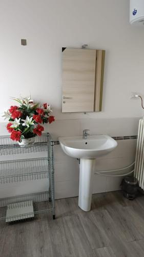 a bathroom with a sink and a vase of flowers at HOTEL Via Emilia Ovest 224 SELF CHECK-IN in Parma