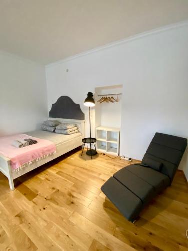 a white room with a bed and a lamp in it at Apartament Pod Tężnią in Głuchołazy
