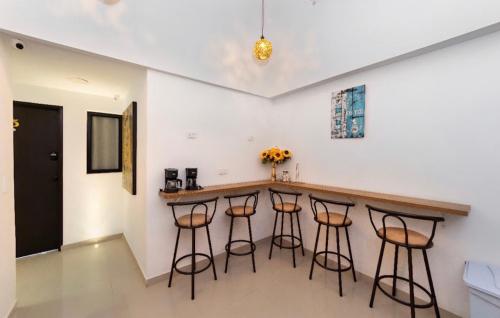 a kitchen with a bar with stools around it at In Situ Hotel in Cali