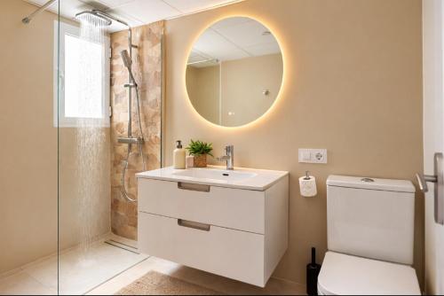 a bathroom with a toilet and a sink and a mirror at Casa MuMa in Calpe