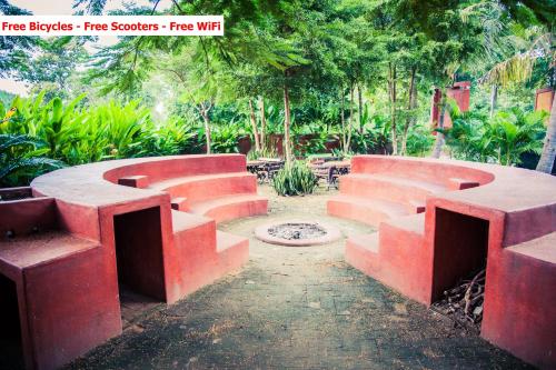 a group of red concrete benches in a park at Baanpong Lodge in San Kamphaeng