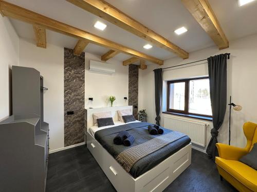 a bedroom with a large bed and a yellow couch at Házikon 2 Apartman in Igricetanya
