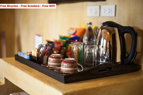 a tray with cups and a tea kettle on a counter at Baanpong Lodge in San Kamphaeng