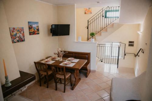 a dining room with a table and a staircase at La Casetta - un piccolo angolo di pace in Piccianello