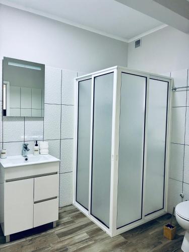 a white bathroom with a toilet and a sink at Seaside & Levada Escape in Machico