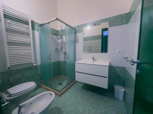 a bathroom with a toilet and a sink and a shower at Affitta camere ALMA MATER in Castrignano del Capo