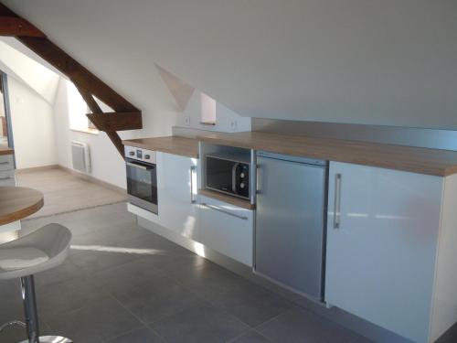 une cuisine avec des armoires blanches et un comptoir en bois dans l'établissement La Greve Saint Michel, à Beauvoir