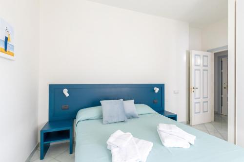 a blue bed with white pillows in a bedroom at Affittacamere 2 Prima Fila Mare in Porto Recanati