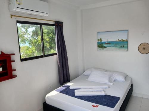 a bed in a room with a window and towels at AMAREA Hotel Boutique in Tolú