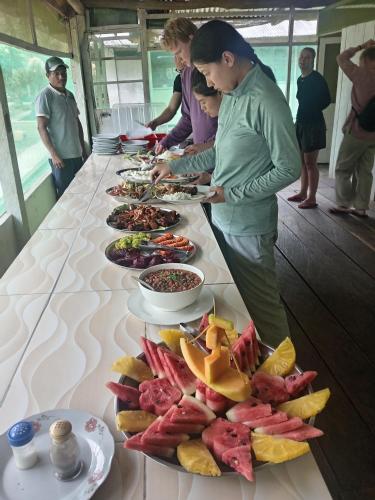 a group of people standing around a table with plates of food at Amazon Lodge Iquitos in Iquitos