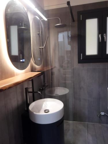 a bathroom with a sink and a shower at The swanky studio in Anatolí