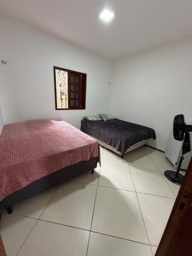 a bedroom with two beds and a window at Paracas House in Paracuru