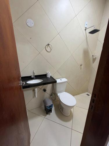 a small bathroom with a toilet and a sink at Paracas House in Paracuru