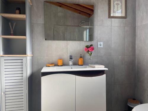 a bathroom with a white sink and a mirror at Maria's Haven in Santo António