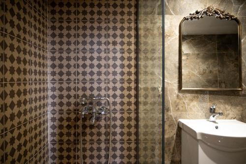 a bathroom with a shower with a sink and a mirror at Old Town Nest in Rhodes Town
