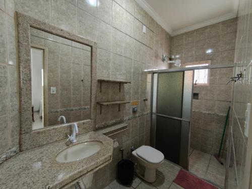 a bathroom with a sink and a toilet and a mirror at Hotel Mirian in Patos de Minas