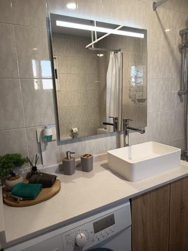 a bathroom with a white sink and a mirror at Apartamentos Demar Luis Casais in O Grove