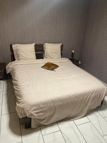 a bed with white sheets and a book on it at Maison appartement cosy au centre-ville in Luxeuil-les-Bains