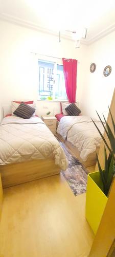 a bedroom with two beds and a potted plant at Cozy appt in Casablanca