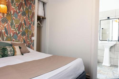 a bedroom with a bed and a sink in a room at La Villa Rose-Marie in Saint-Brevin-les-Pins