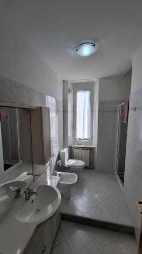 a bathroom with two sinks and a toilet and a window at Buonviaggio in La Spezia
