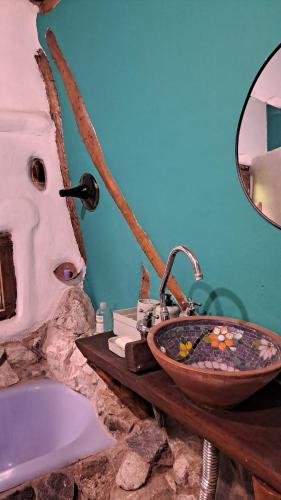 a bathroom with a stone sink and a tub at Biocasa in Villa Anizacate