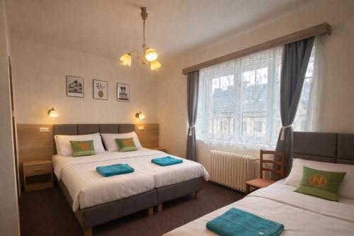 a bedroom with two beds and a window at Penzion u Fouska in Chodov
