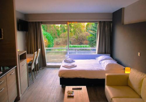 Habitación de hotel con cama, sofá y ventana en Value Stay Residence Mechelen en Mechelen