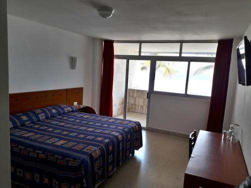 a bedroom with a bed and a window and a table at Hotel Royalty in Veracruz