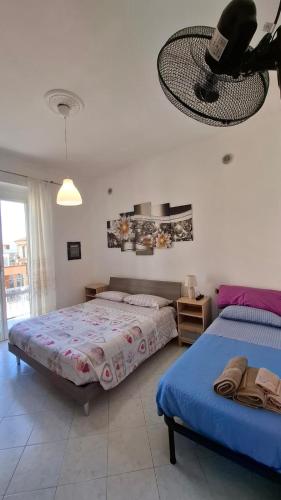 a bedroom with two beds and a fan at Buonviaggio in La Spezia