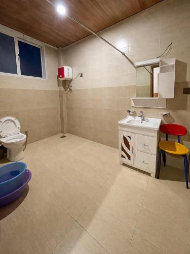 a bathroom with a toilet and a sink at Nathia Lodge Cottage in Nathia Gali