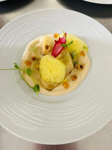 a plate of food on a white plate at Hôtel Le Castanea Entre Aurillac et Marcolès Auvergne in Roannes-Saint-Mary