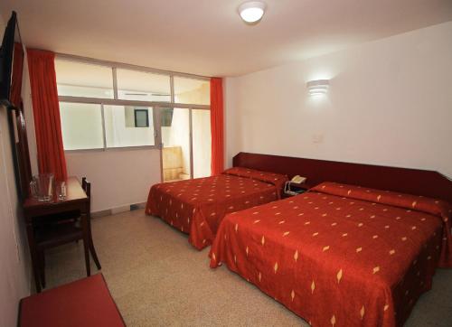 a hotel room with two beds and a window at Hotel Royalty in Veracruz