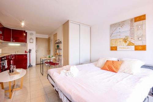 a large white bed in a room with a kitchen at La Clé des Sternes in Camiers