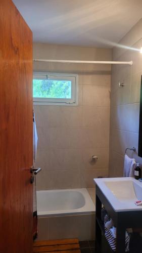 a bathroom with a tub and a toilet and a sink at Lihuen in Mar Azul