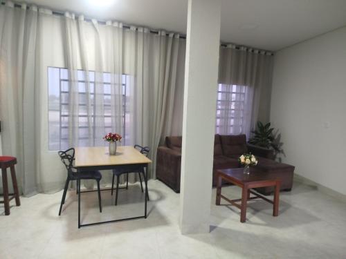 a living room with a table and a couch at DSá Hotel in Cristalândia