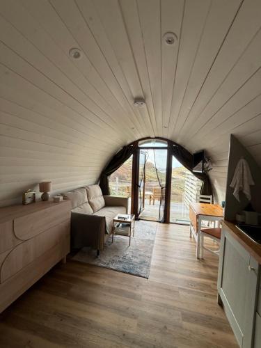 a living room with a couch and a table at Handa pod in scottish highlands. in Scourie
