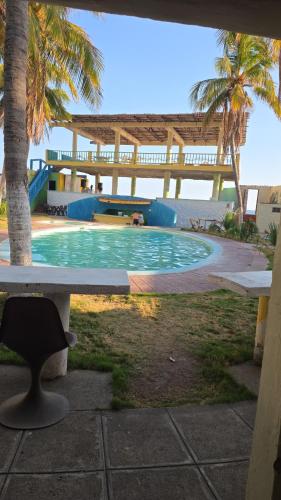 a swimming pool with a table and a chair at Entre olas in La Libertad