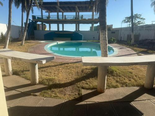 two benches sitting in front of a swimming pool at Entre olas in La Libertad