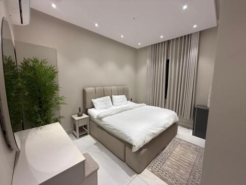 a bedroom with a bed and a potted plant at Al Hamra Modern Suite, Khobar in Al Khobar