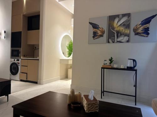 a living room with a table and a kitchen at Al Hamra Modern Suite, Khobar in Al Khobar