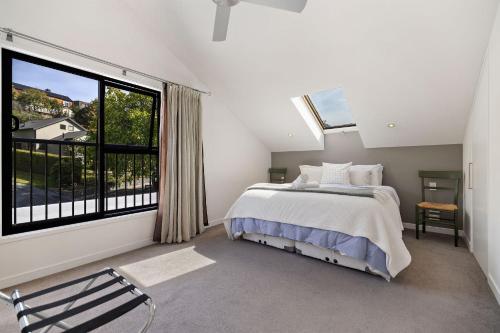 a bedroom with a bed and a large window at Chartres Retreat in Arrowtown