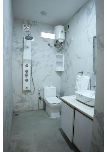 a bathroom with a toilet and a sink at Raskunj Farm in Noida