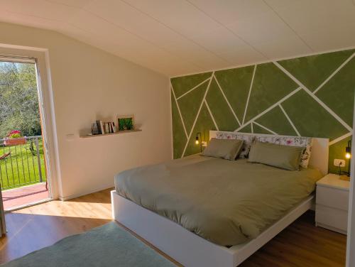 a bedroom with a large bed with a green wall at B&B Il sentiero del bosco in Buia
