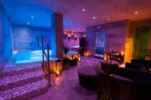 a room with a swimming pool and a sitting area at Hotel Costazzurra Museum & Spa in San Leone