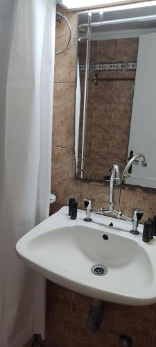 a white sink in a bathroom with a mirror at Bambola Apartments in Nea Moudania