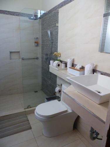 a bathroom with a toilet and a sink and a shower at Hotel Villa Romantica in Manuel Antonio