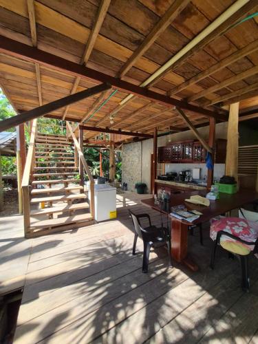 a patio with a wooden roof with a table and chairs at Cabaña LA IGUANA in Capurganá