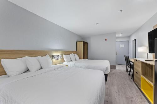 a hotel room with two beds and a desk at Day Inn by Wyndham San Antonio Downtown in San Antonio